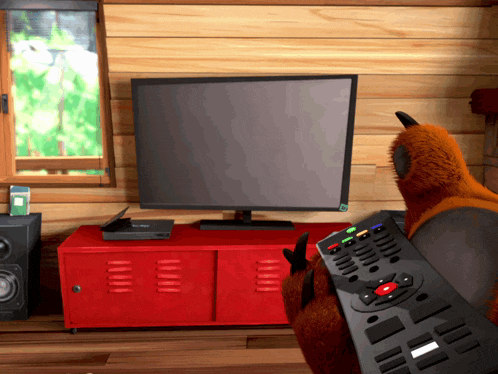 a bear holding a remote control in front of a television
