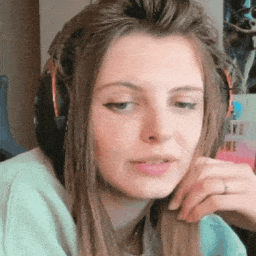 a woman wearing headphones looks at the camera