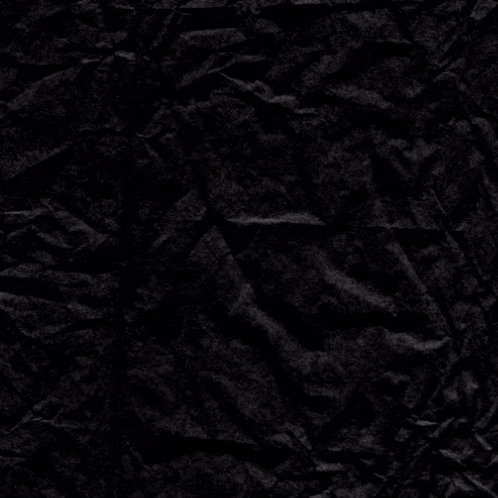 a crumpled piece of black paper with a white cross in the middle