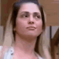 a woman with long blonde hair is making a funny face and looking at the camera .