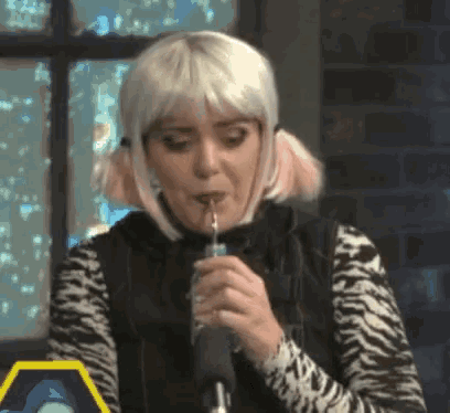 a woman in a zebra print shirt drinks from a straw