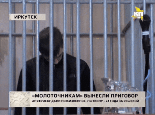 a man is behind bars on a tv screen that says kp