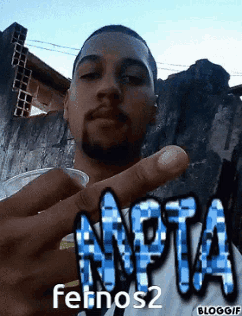 a man holding a cup with the word npta on his shirt