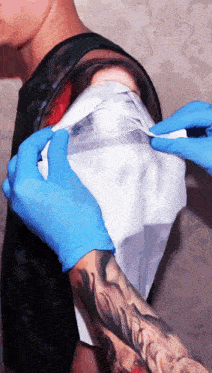a person with a tattoo on their arm is getting a bandage on it