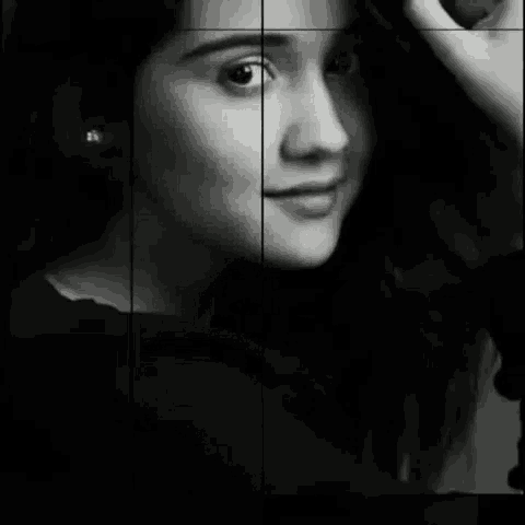 a black and white photo of a woman 's face with a hand on her head .