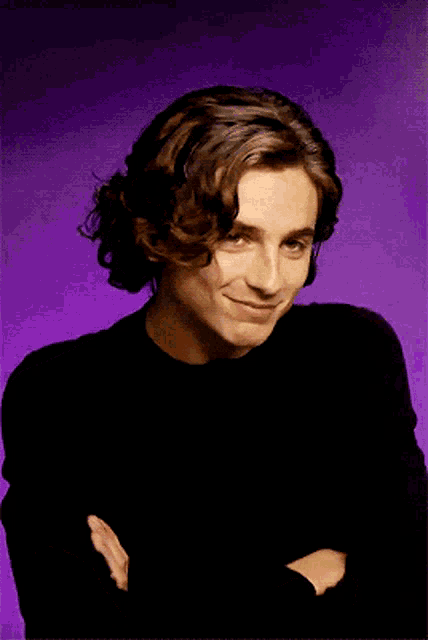 a young man with curly hair wearing a black shirt
