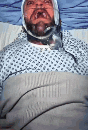 a man in a hospital gown with a bandage on his head