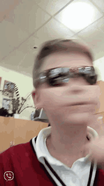 a blurry picture of a person wearing sunglasses and a red shirt