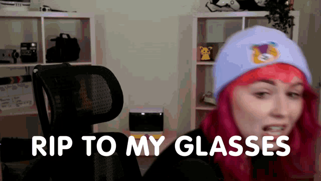 a woman with pink hair is sitting in a chair and says rip to my glasses