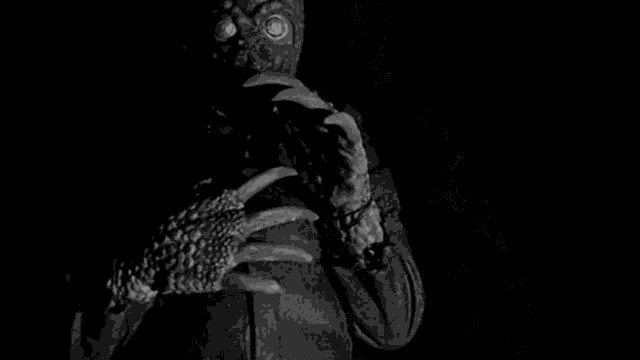 a black and white photo of a monster with large claws .