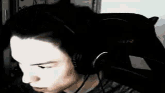 a man is sitting in a chair in a dark room and making a funny face .