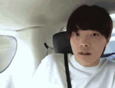 a young man is sitting in the back seat of a car with his mouth open .