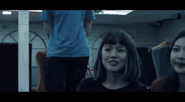 a man in a blue shirt stands next to two women