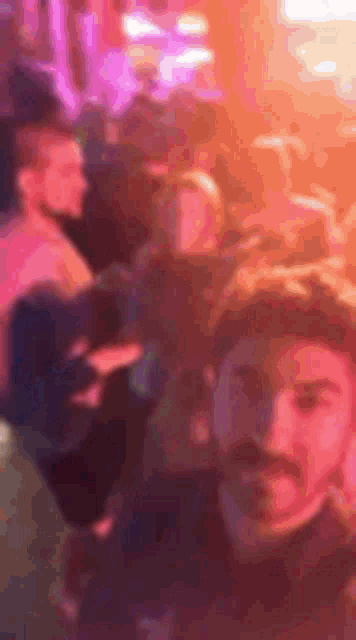 a man is taking a selfie in front of a crowd of people at a party .