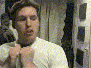 a man wearing a white shirt and a black tie is standing in front of a mirror .