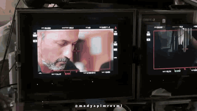 a man with a beard is being filmed on a screen with the letter b on it