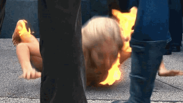 a person laying on the ground with fire coming out of their face