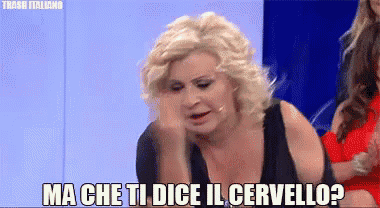 a woman in a black dress is making a funny face and says ma che ti dice il cervello