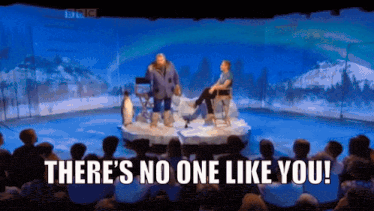 a group of people sitting in front of a stage with the words " there 's no one like you " on it