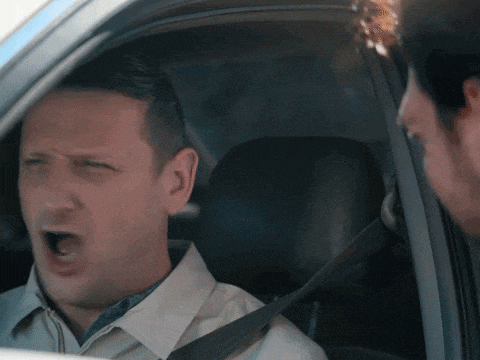 a man in a car with his mouth wide open