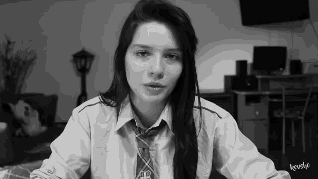 a black and white photo of a girl wearing a shirt and tie with the word kruslyo on the bottom