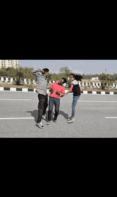 a group of people are standing on a road and one of them is holding a man 's hand