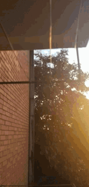 the sun is shining through the trees behind the building