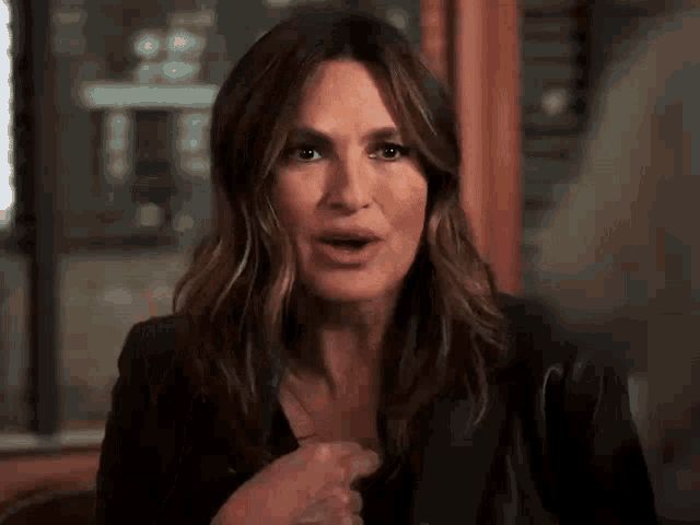 a woman is making a funny face while wearing a black jacket .