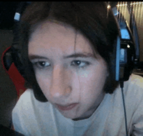 a young woman wearing headphones looks at the camera