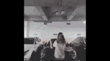 a woman is dancing in a parking garage .