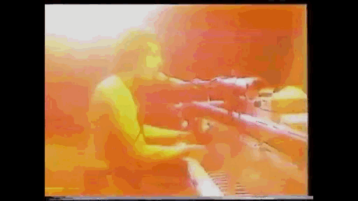a man is playing a piano in a room with a lot of lights