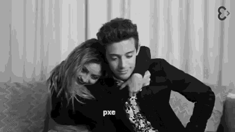 a black and white photo of a man and a woman hugging each other .