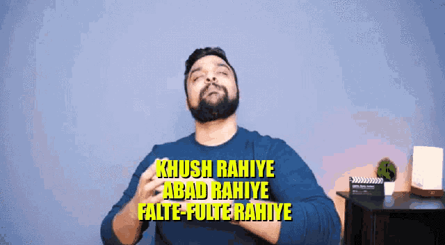 a man in a blue shirt says " khush rahiye abad rahiye falte-fulte rahiye " in yellow letters