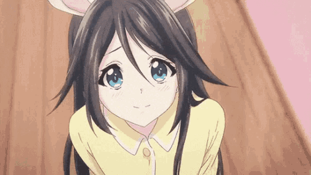 a cute anime girl with long black hair and blue eyes is wearing bunny ears .