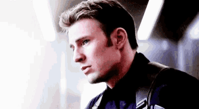 a close up of a man 's face wearing a black jacket and tie .