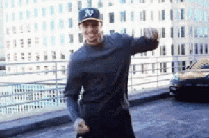 a man wearing a ny yankees hat is standing on a sidewalk