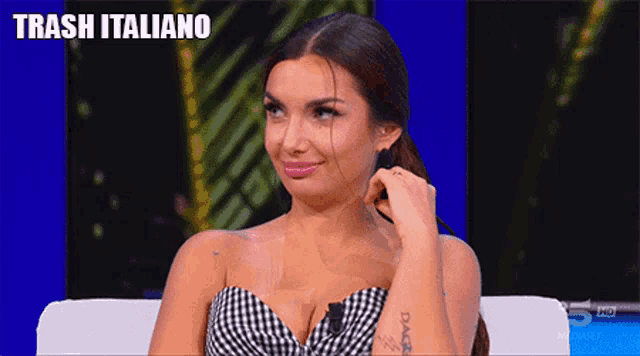 a woman sitting on a couch with trash italiano written on the top