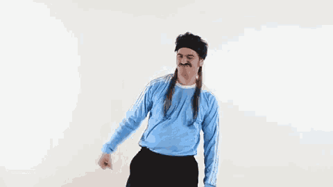 a man with dreadlocks and a mustache is dancing in a blue adidas shirt .