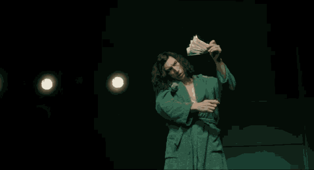 a man in a green robe is burning money