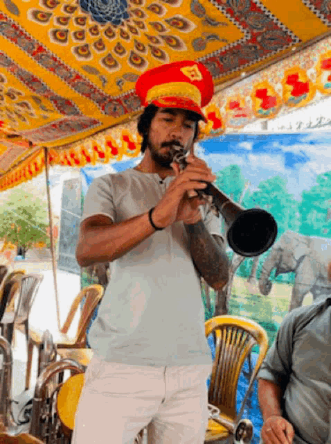 a man in a red hat is playing a trumpet