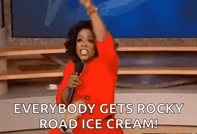 a woman in a red dress is holding a microphone and saying `` everybody gets rocky road ice cream '' .