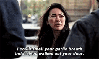 a woman is talking to a man and says `` i could smell your garlic breath before you walked out your door . ``