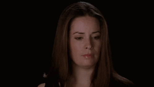 a close up of a woman 's face with her eyes closed against a black background