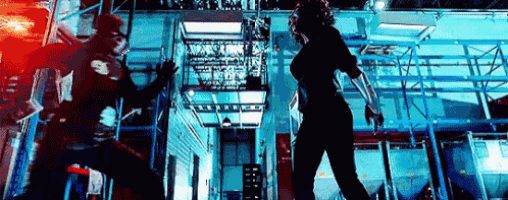 a man and a woman are fighting each other in a warehouse .