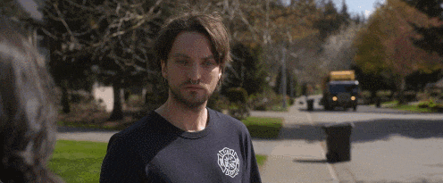 a man with a beard wearing a black t-shirt with the word fire on it