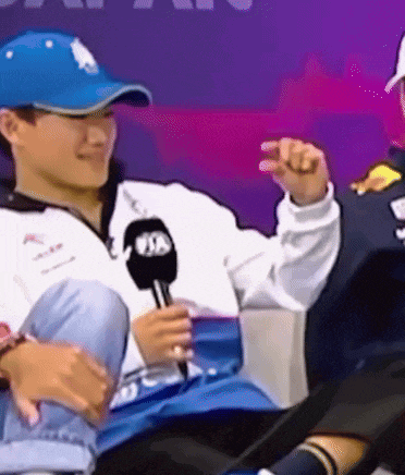a man wearing a blue hat is holding a microphone that says fia on it