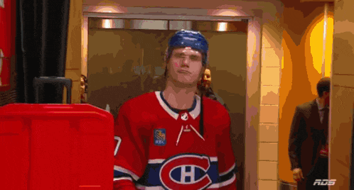 a hockey player in a red and white jersey with the letter h on it