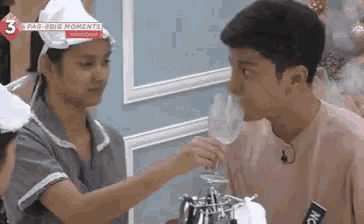 a man and a woman are standing next to each other and the man is drinking from a glass