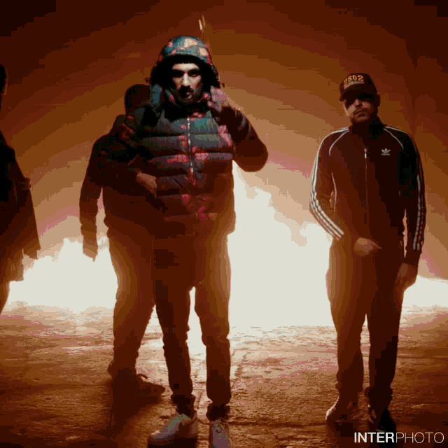 a group of men are standing in front of a fire and the word interphoto is on the bottom left
