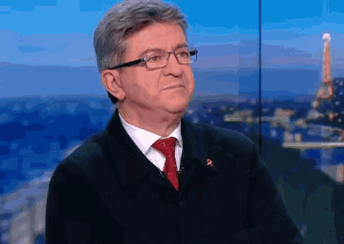 a man wearing glasses and a red tie stands in front of a blue sky